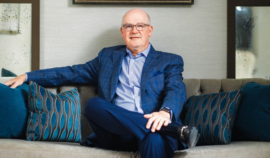 Man in blue suit sitting on a sofa.