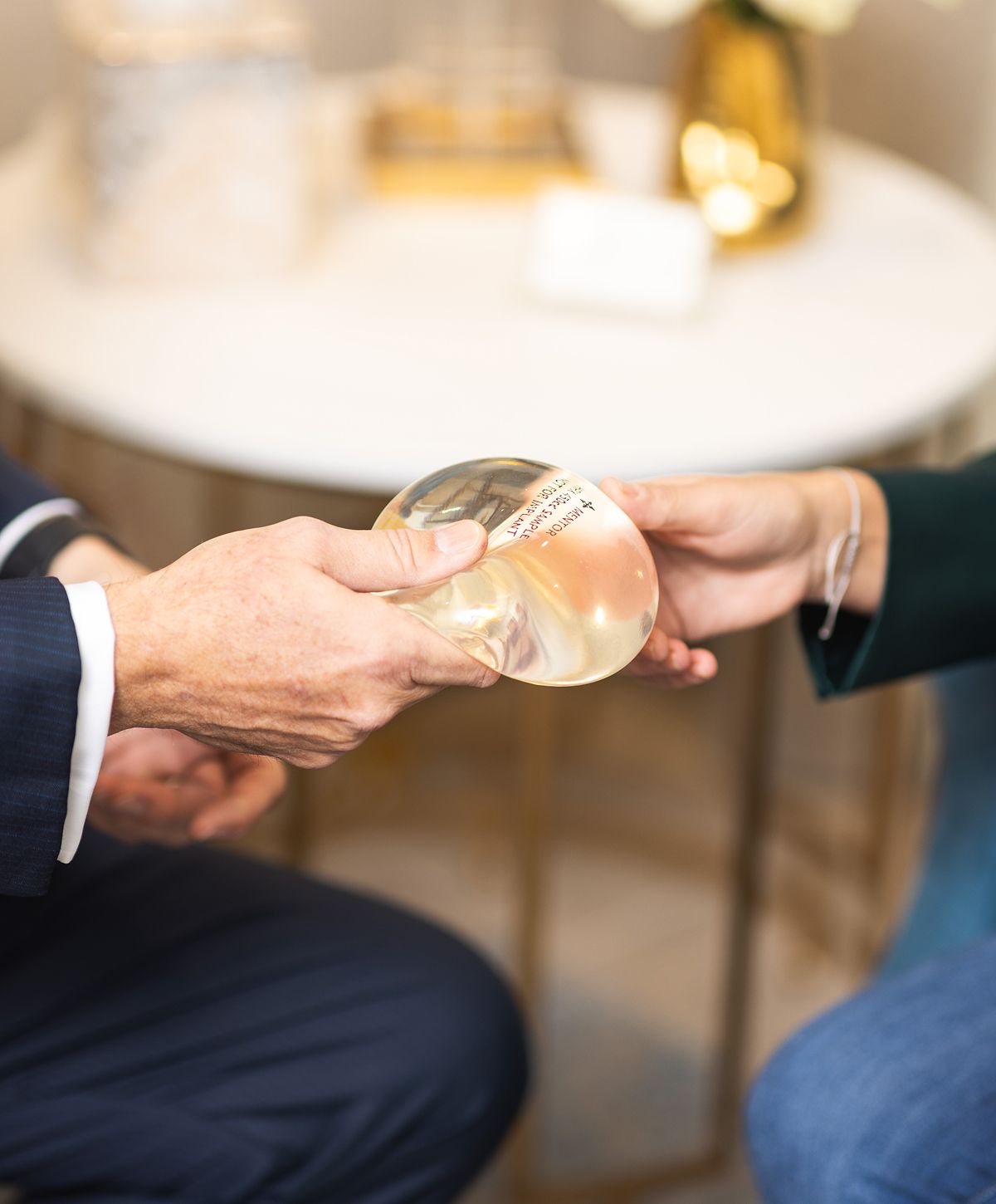 Hands exchanging a clear round object.