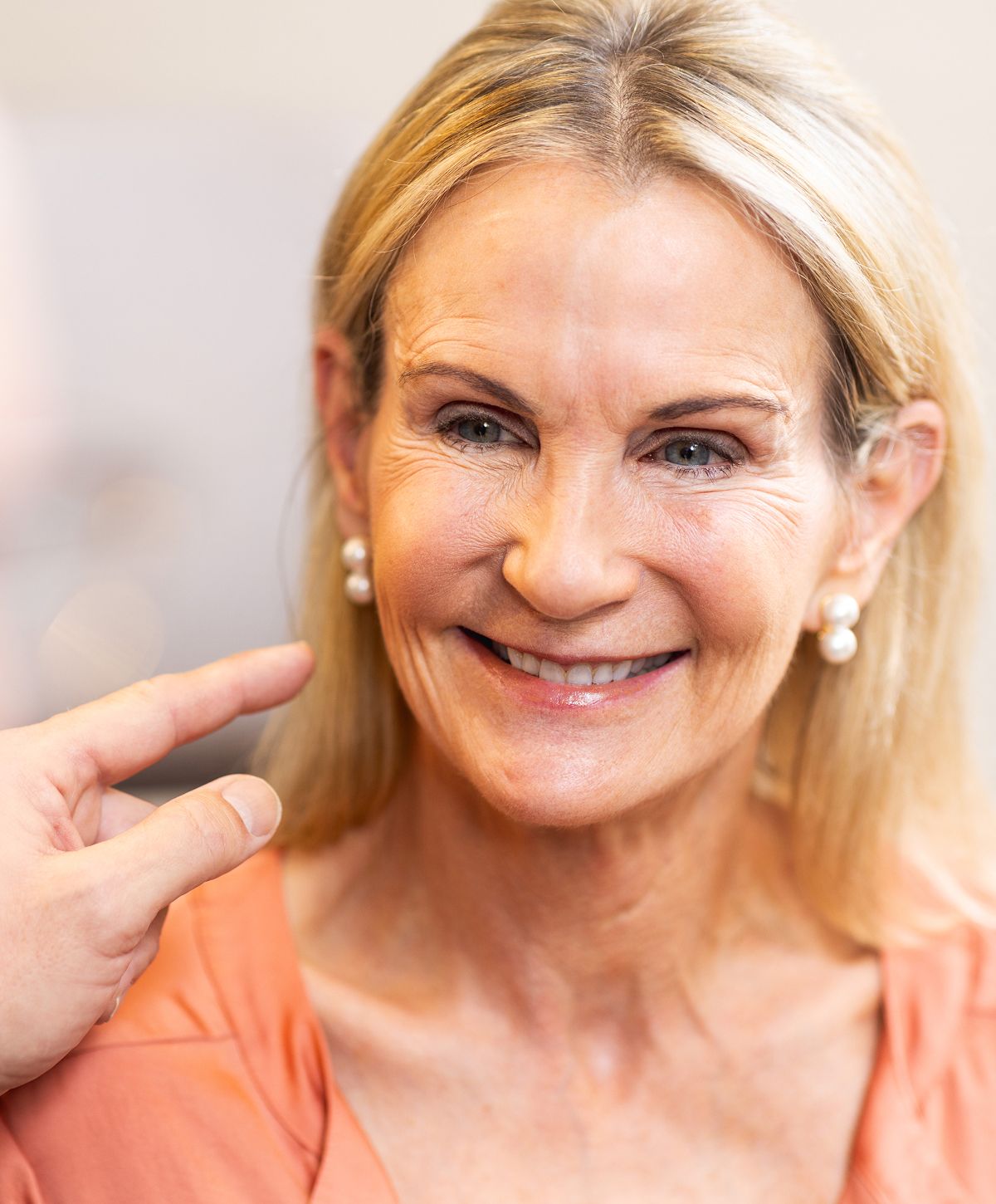 Smiling woman with earrings and gentle touch.