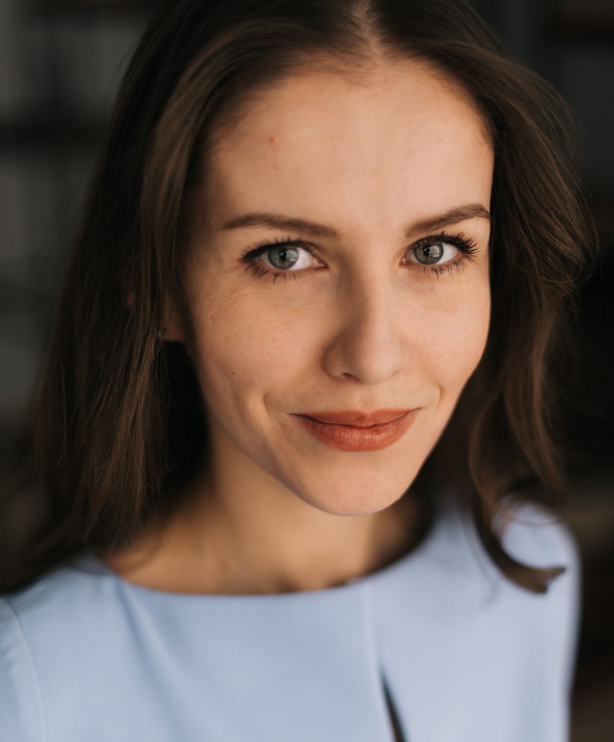 Portrait of a smiling woman in blue top.