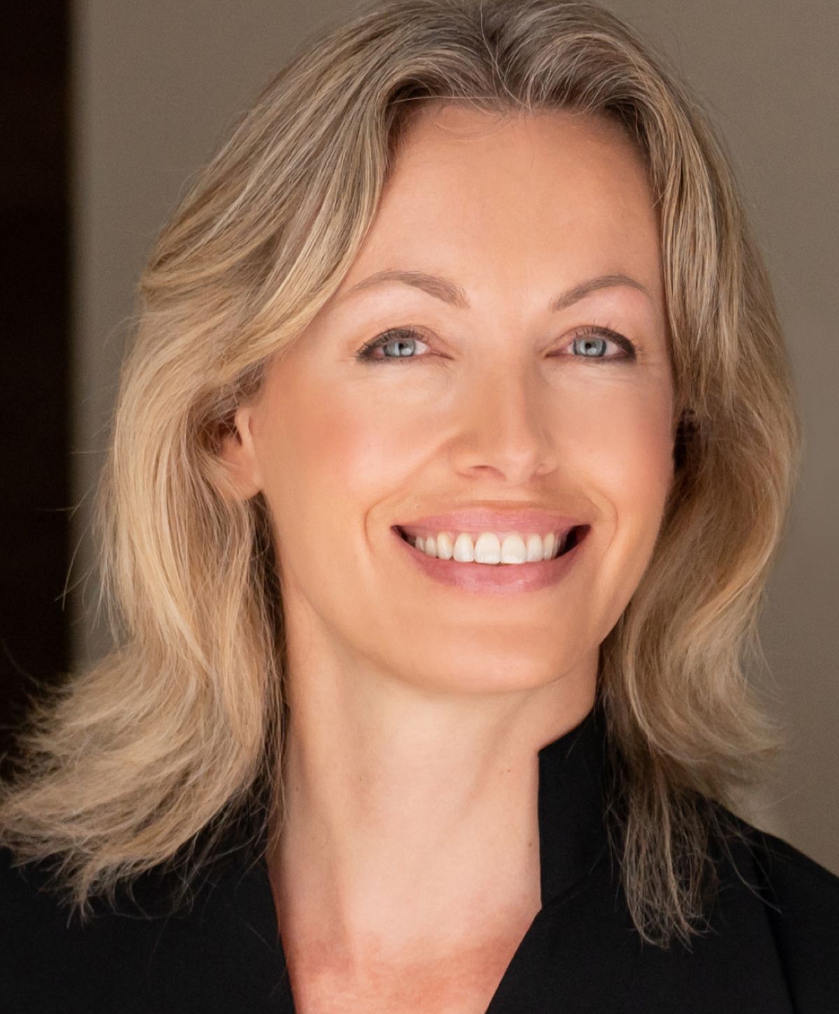 Smiling woman with light hair and blue eyes.
