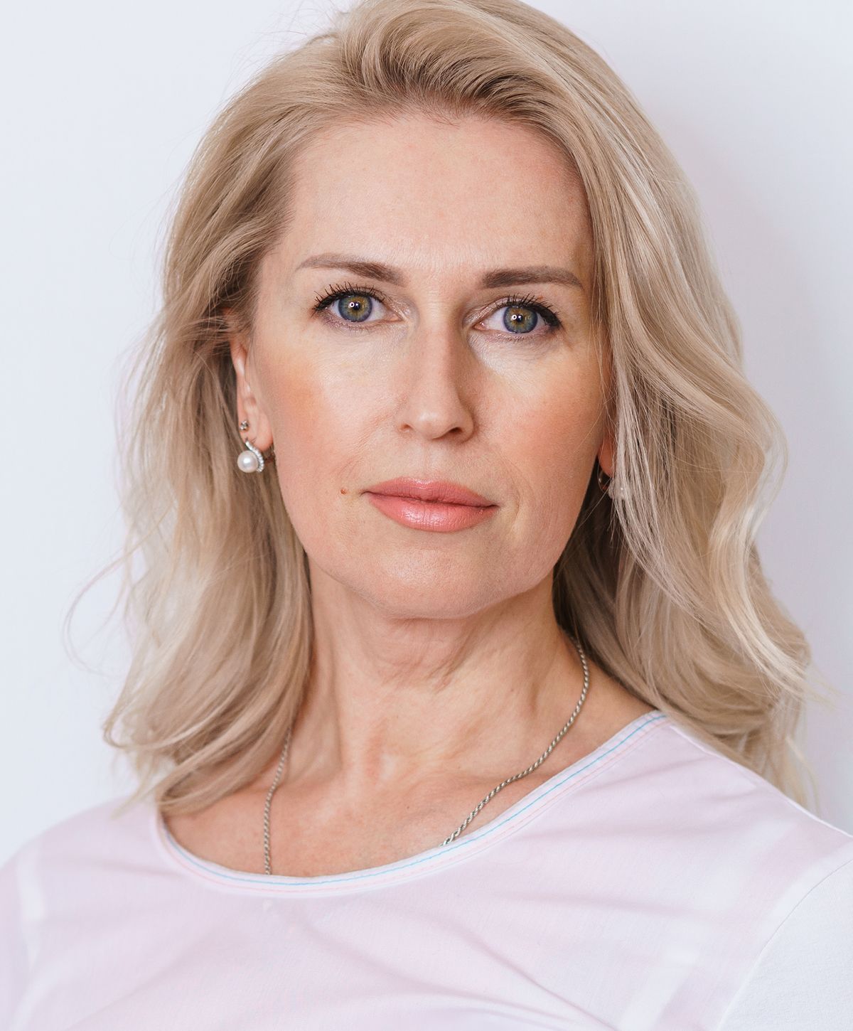 Woman with blonde hair and natural makeup.