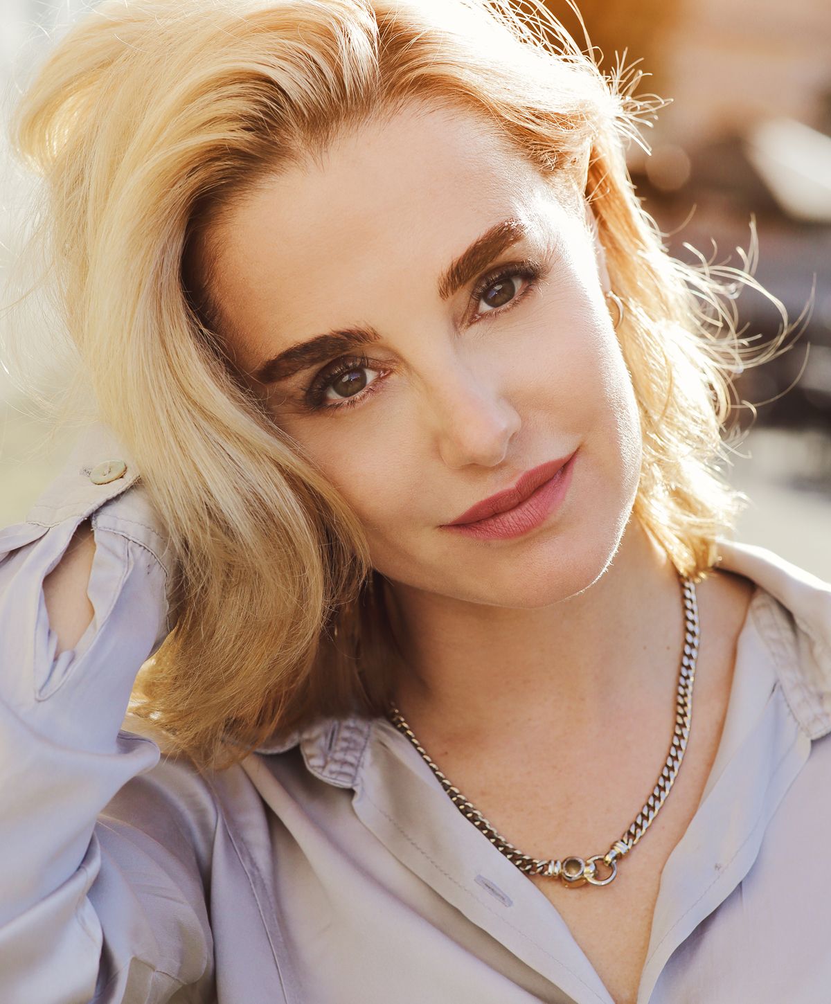 Woman with blonde hair and silver necklace.