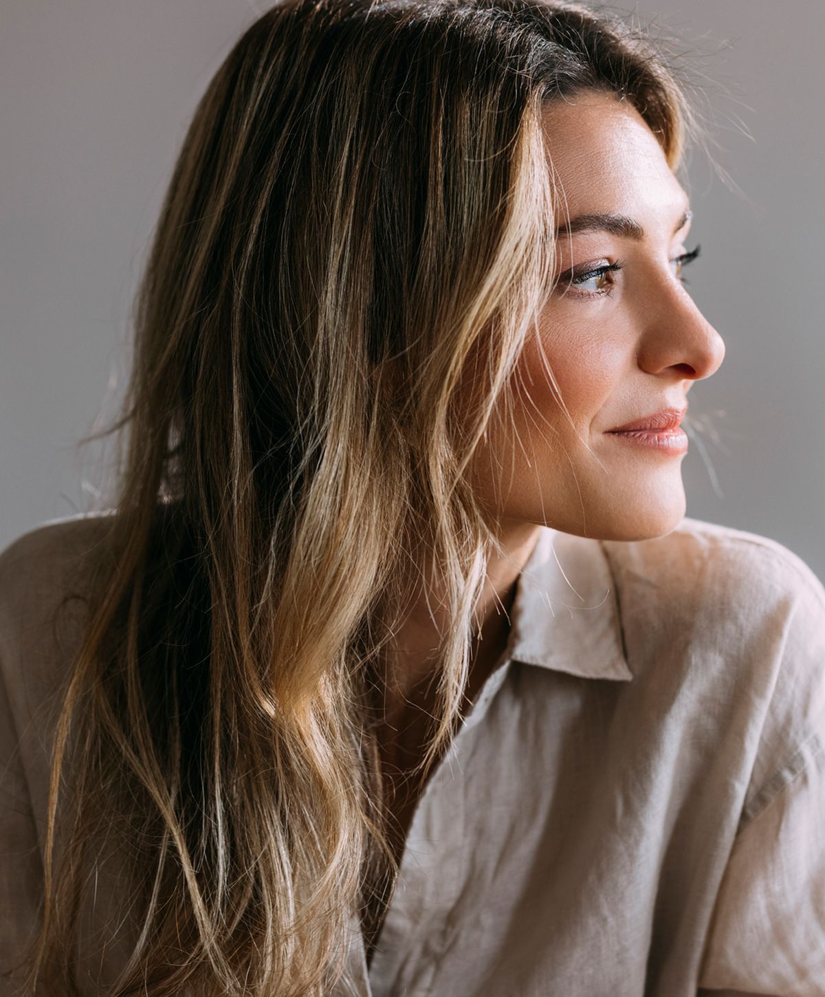 Woman with long hair, profile view, natural light.