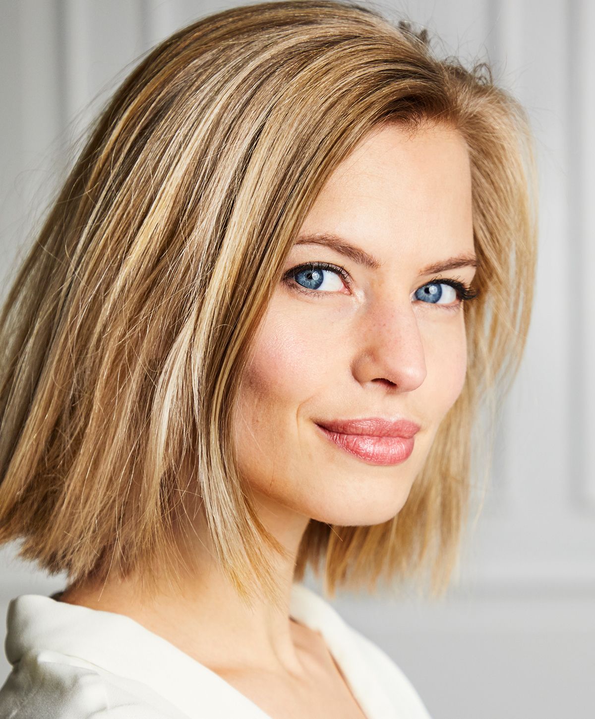Woman with blonde hair and blue eyes smiling.