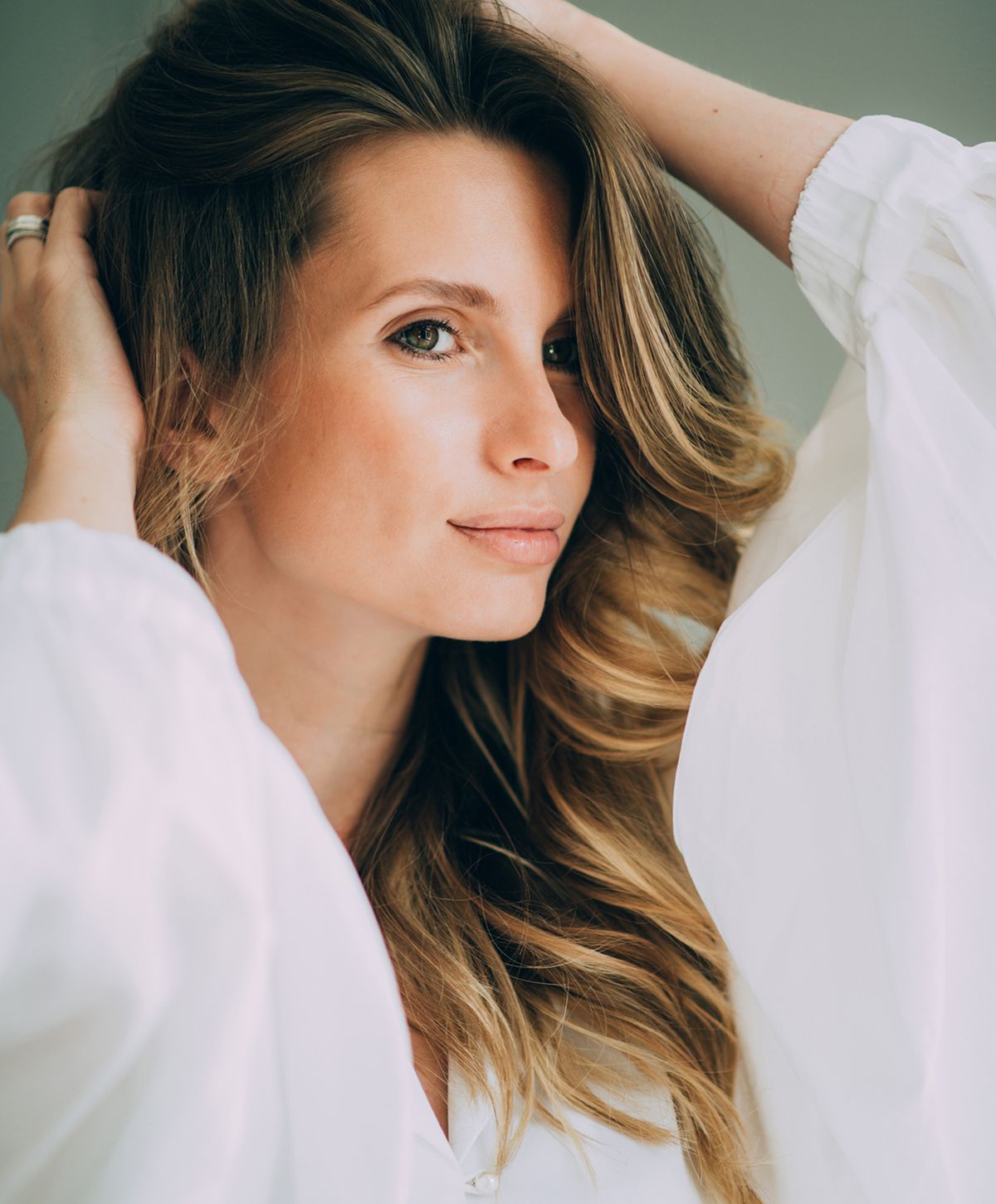 Woman smiling, holding oversized jeans, healthy lifestyle.