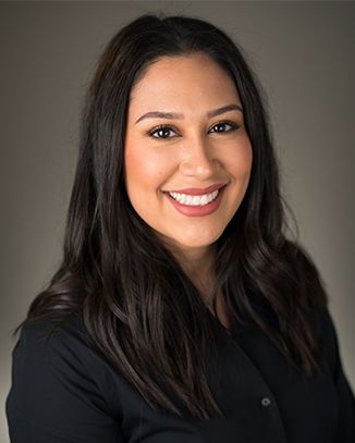 Smiling woman with long dark hair.