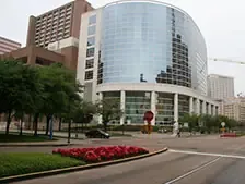 Modern glass building with landscaping and flowers.
