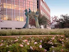 Sculptures in garden near modern building.