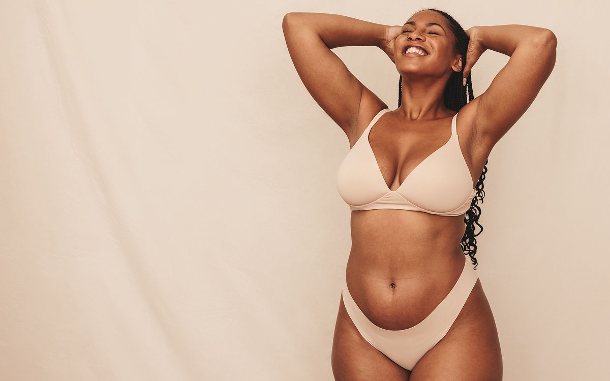 Smiling person enjoying their confidence in lingerie.