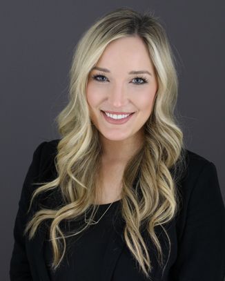 Smiling woman with long blonde hair, professional attire.