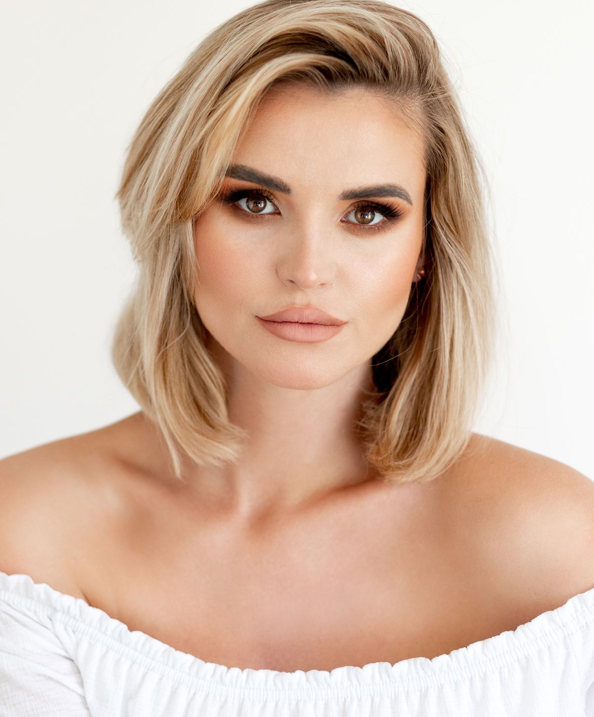Woman with short blonde hair and natural makeup.