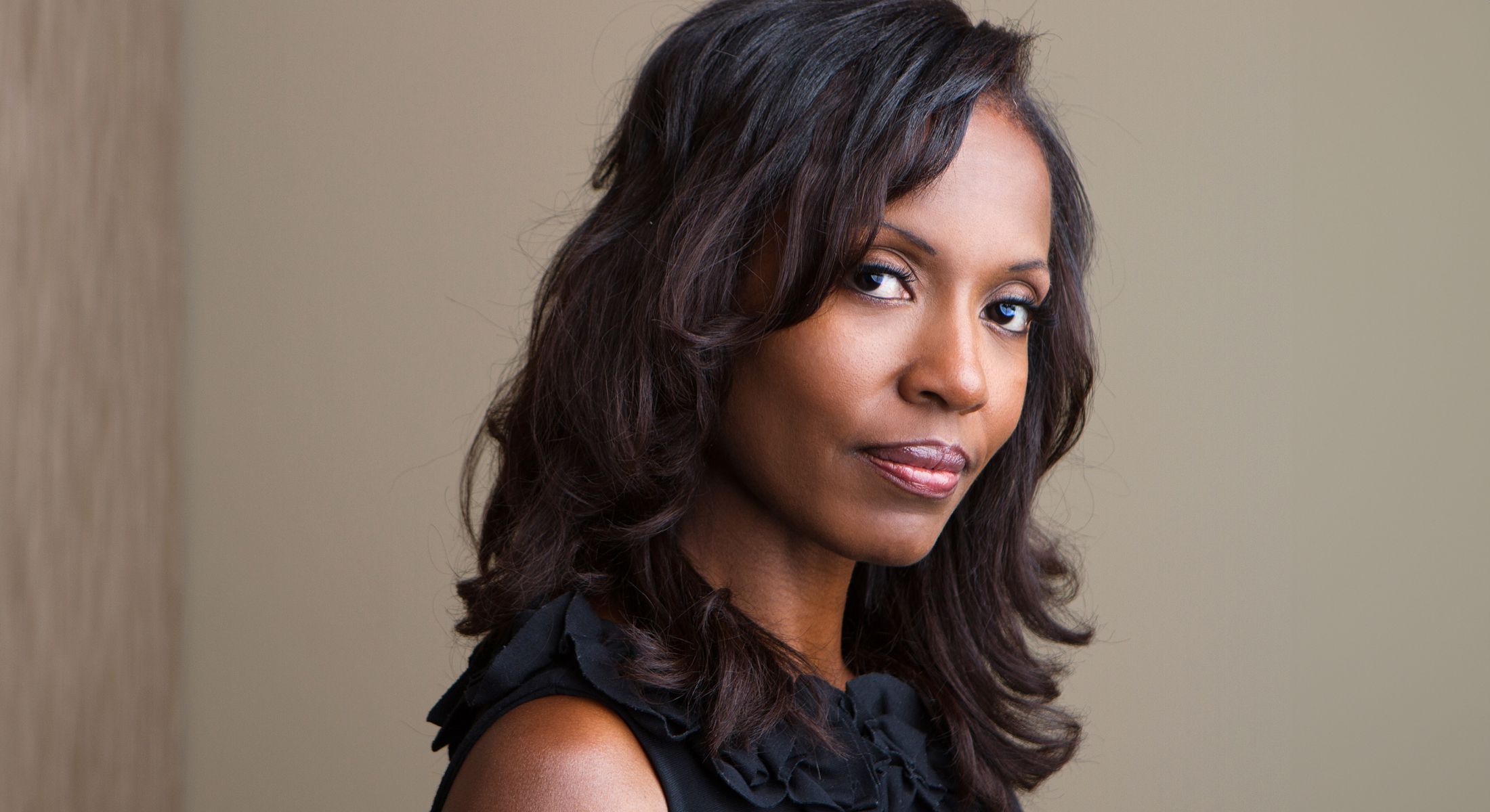 Portrait of a woman with dark, wavy hair.