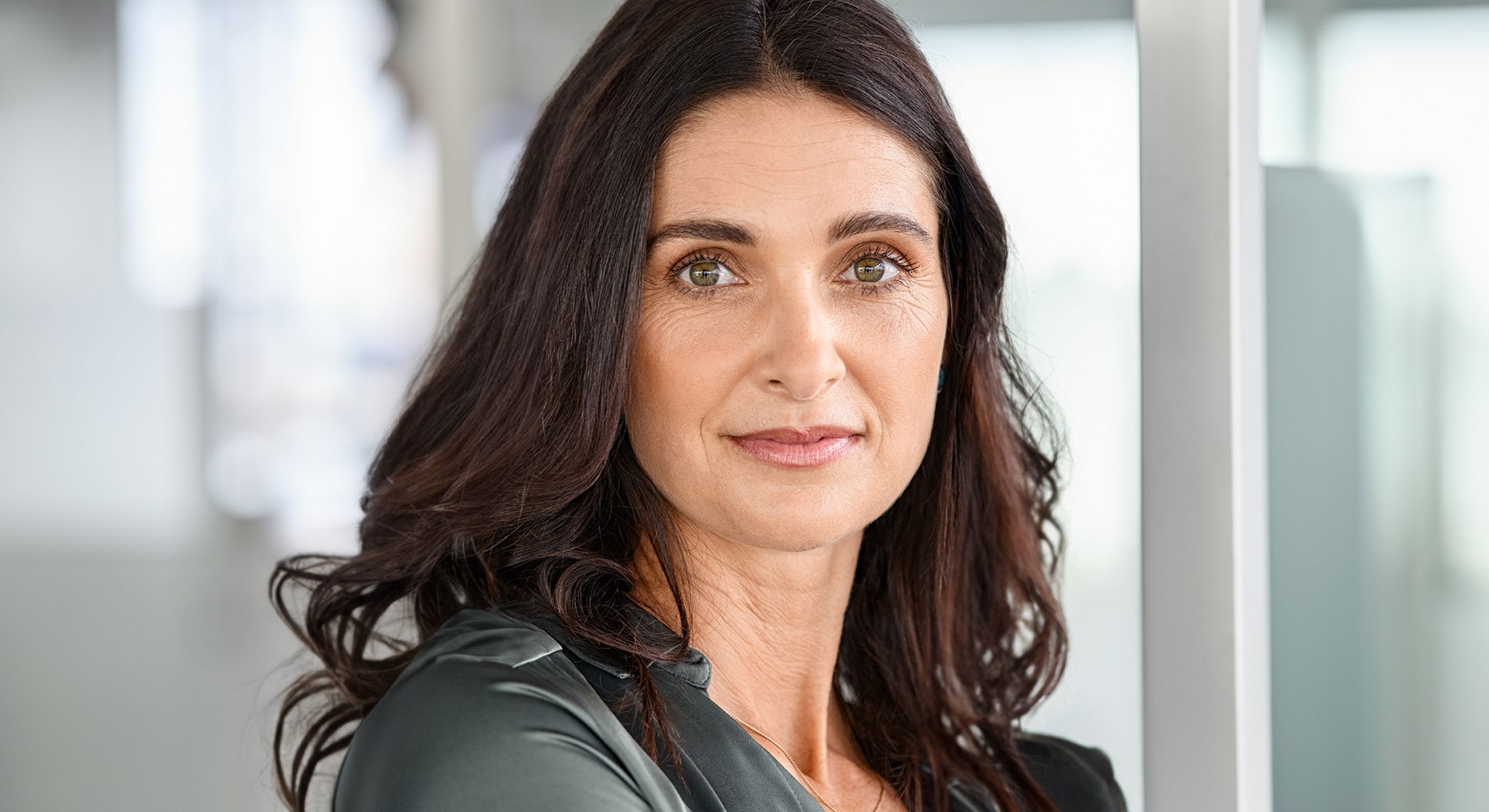Woman with long dark hair and green eyes.