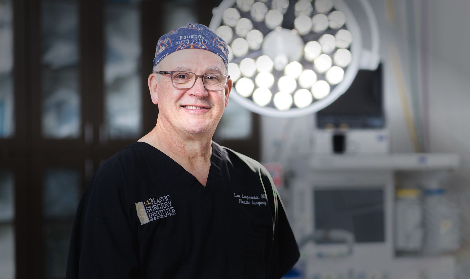 Surgeon smiling in an operating room setting.