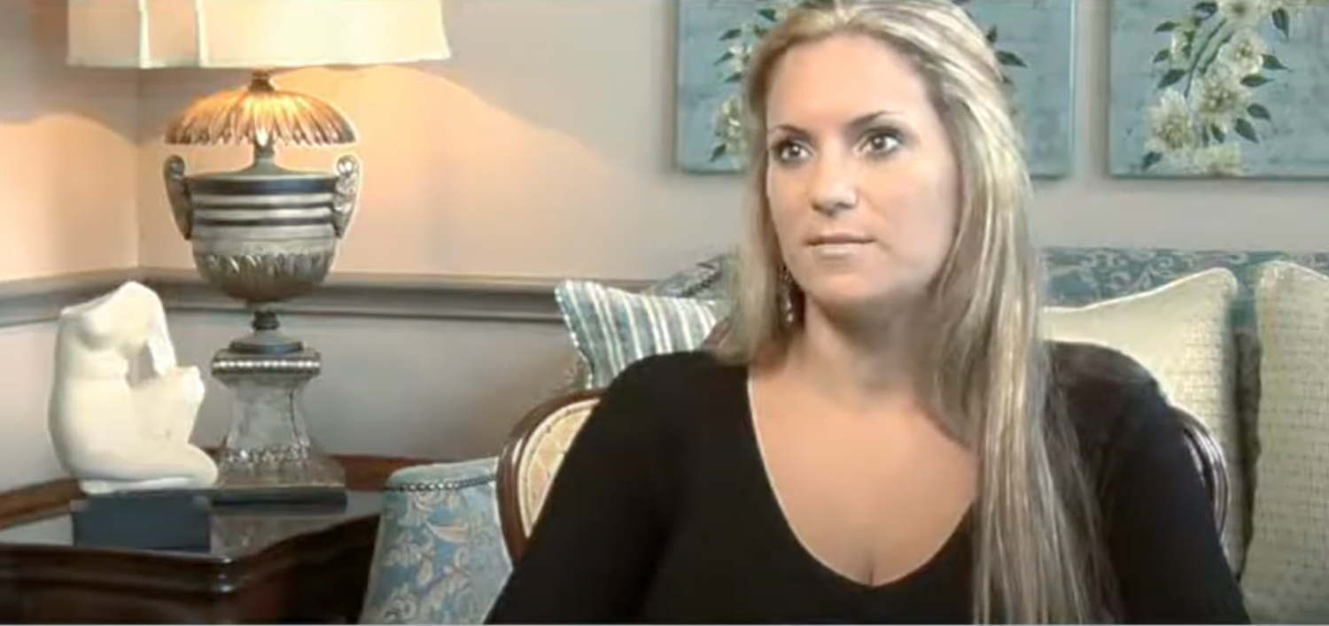 Woman speaking in a cozy living room setting.