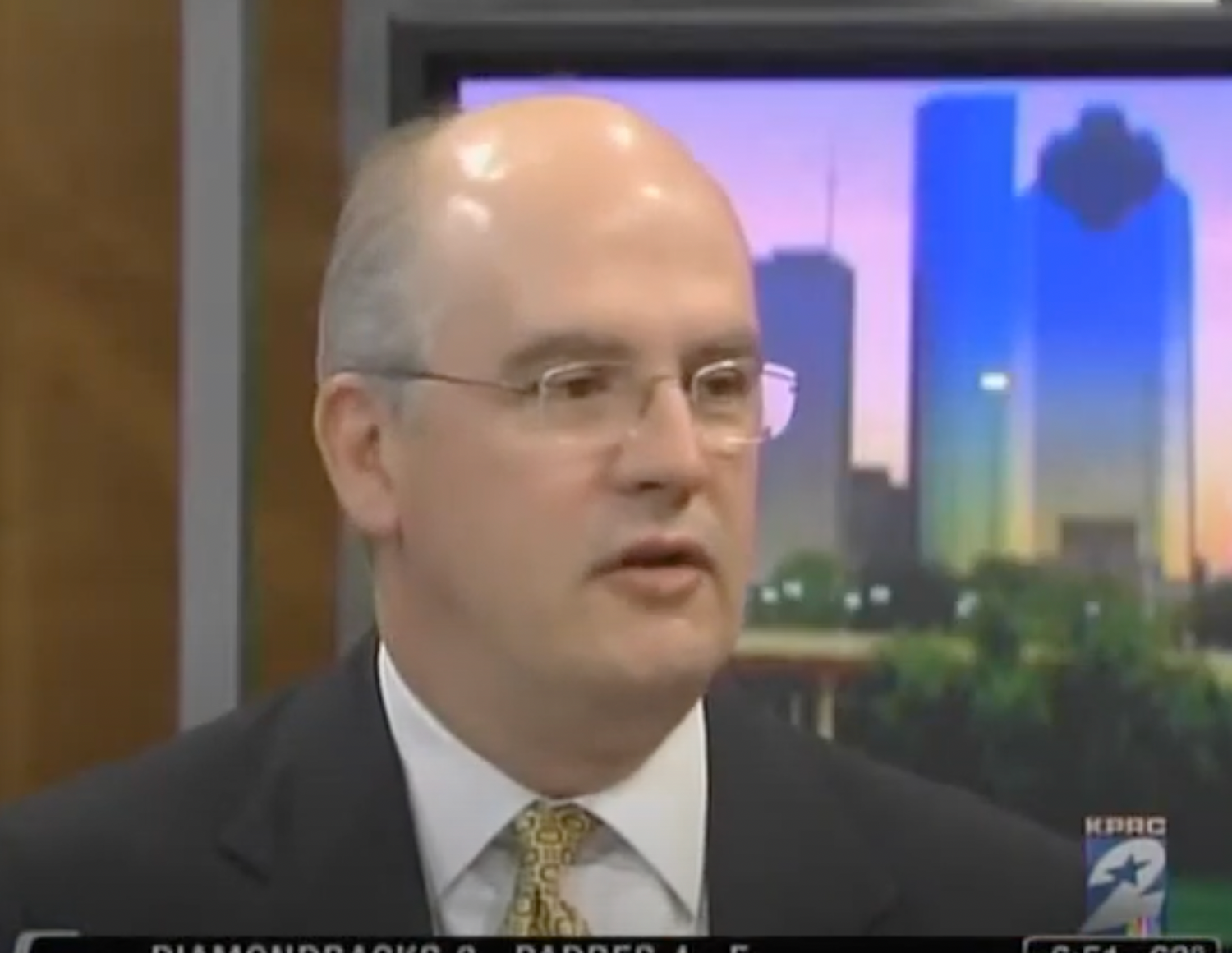 Man speaking on television set background.