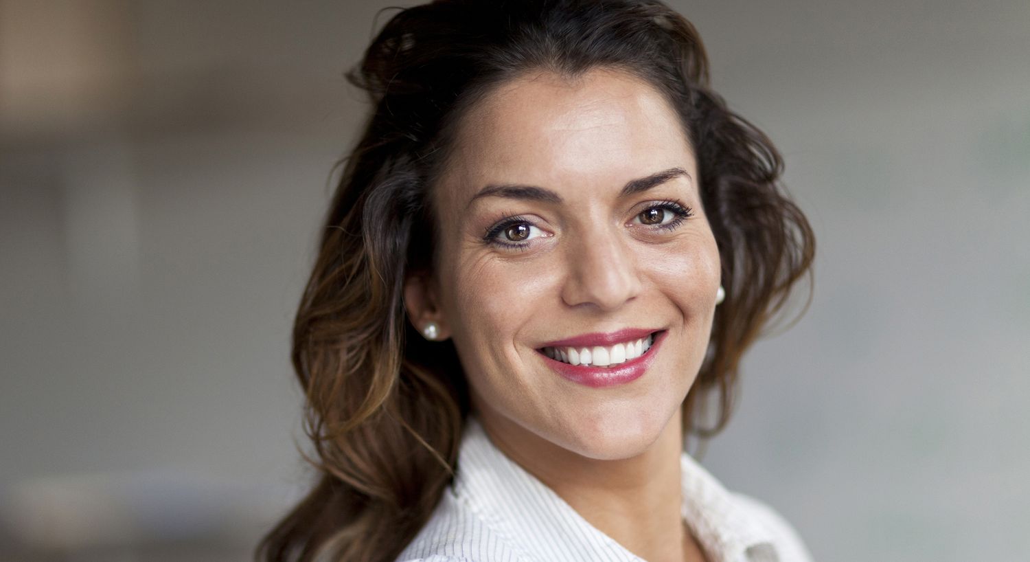 Smiling woman with long hair in a casual setting.