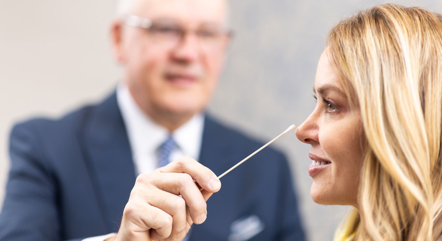 Doctor examining patient with cotton swab applicator.